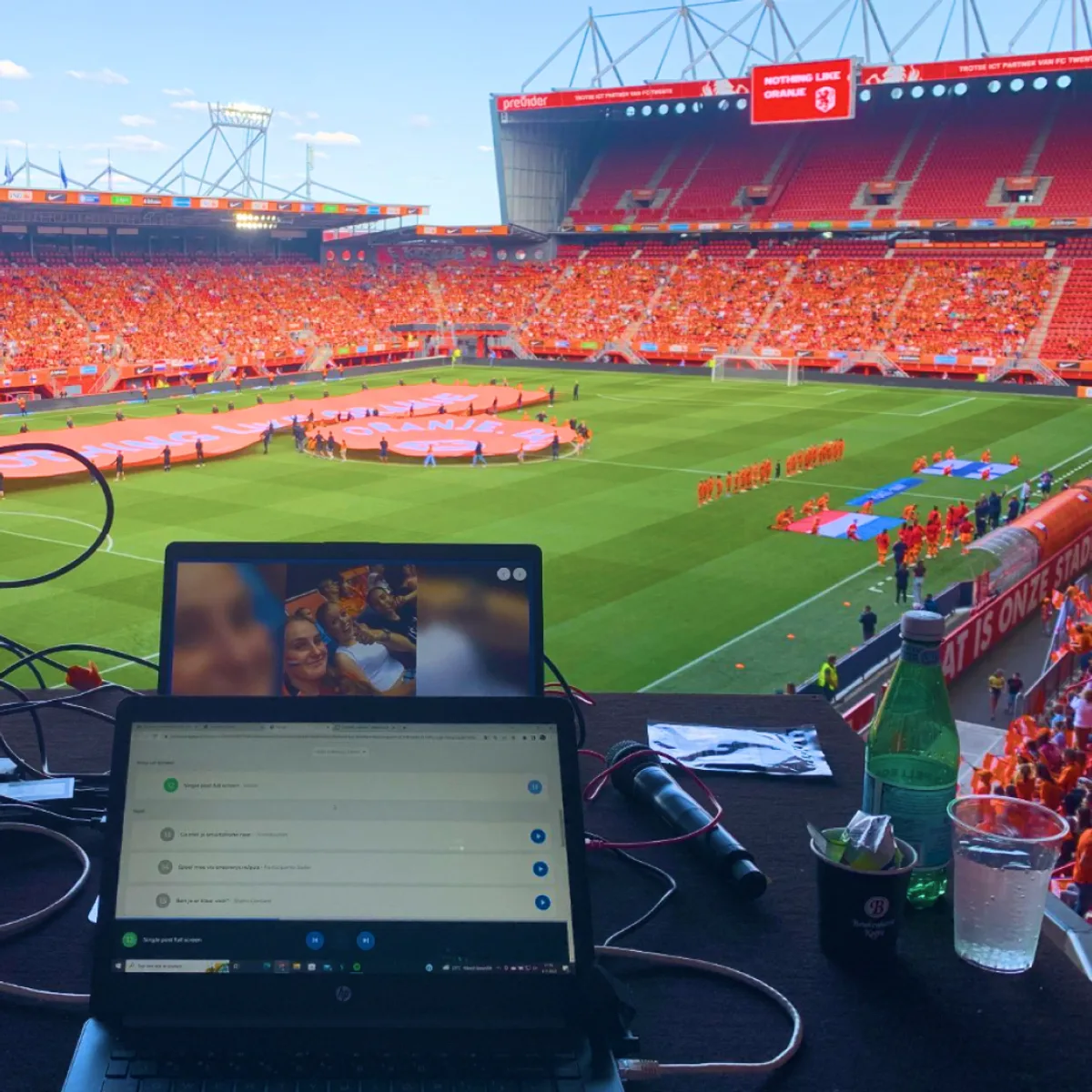 The Fan of the Match moderation desk overlooking an orange-packed stadium at a KNVB matchday