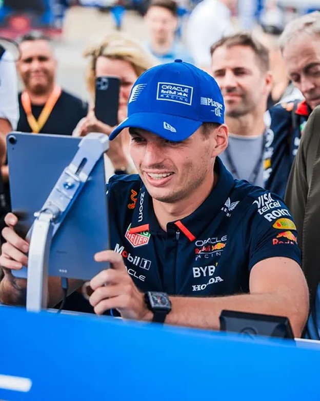 Max Verstappen playing Player 0.0 on a tablet at a fan event